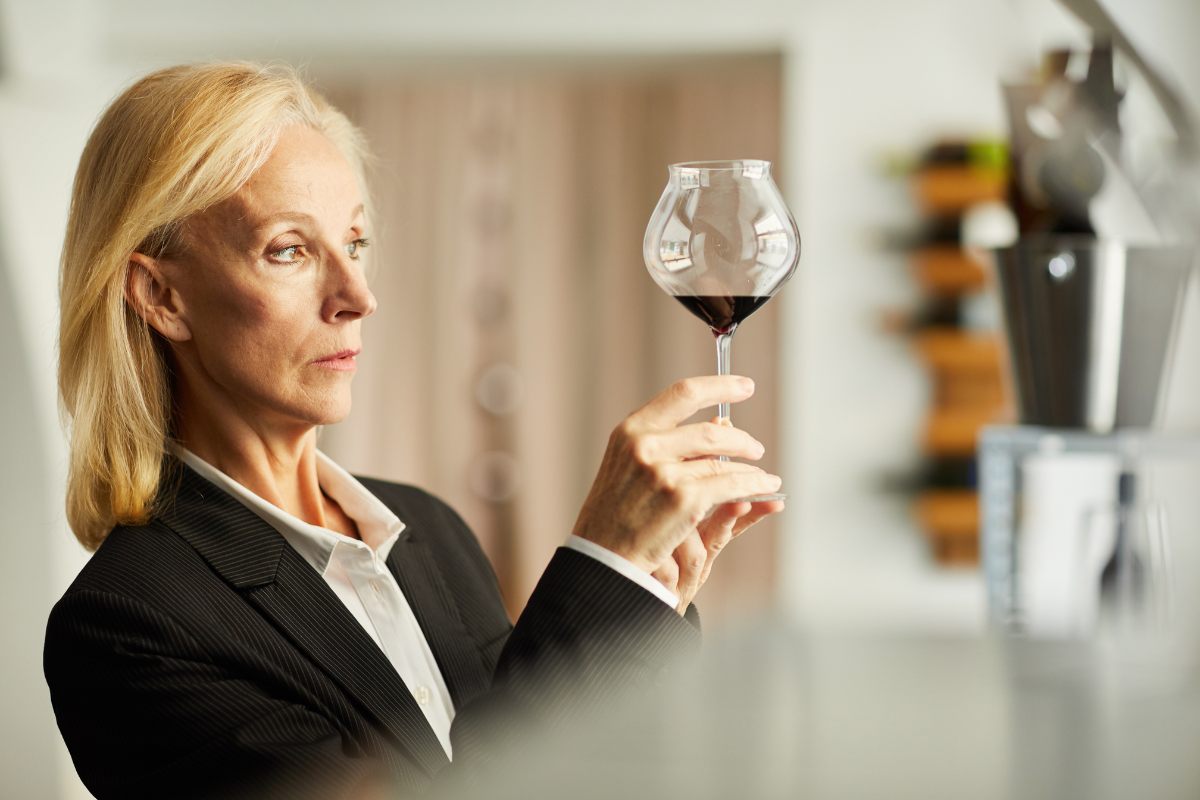 Female sommelier examining a wine.