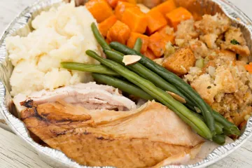Turkey dinner leftovers packed in a foil tray.