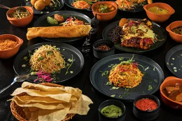 A selection of Sri Lanckan dishes on a dark wood table.