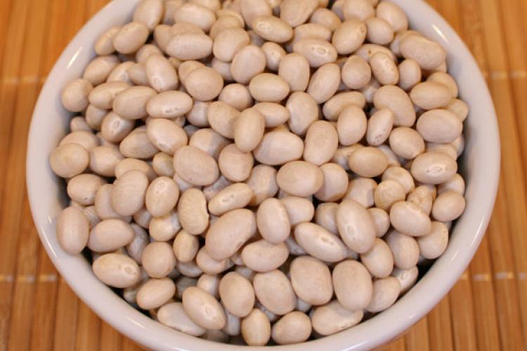 Dry haricot beans in a white container.
