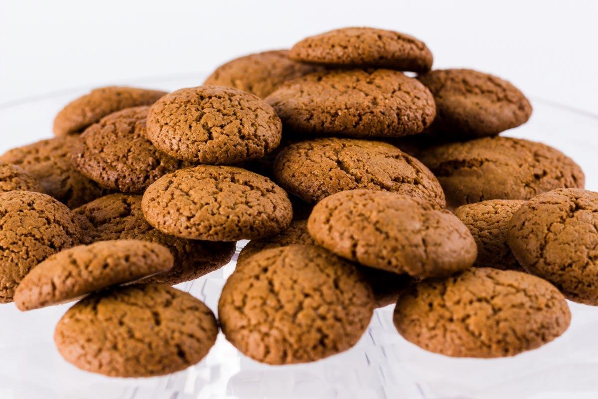 A pile of traditional speculaas biscuits with a crisp, golden-brown appearance.