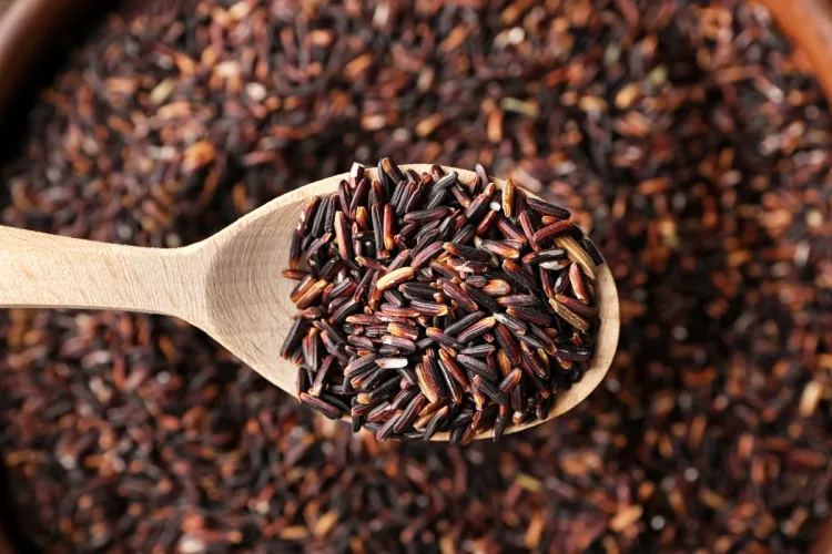 A wooden spoon with wild rice.