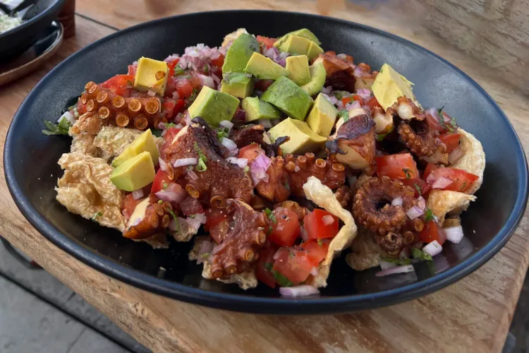 Crispy ocotups bites, chicharrón de pulpo, in  a plate on a wooden table. 