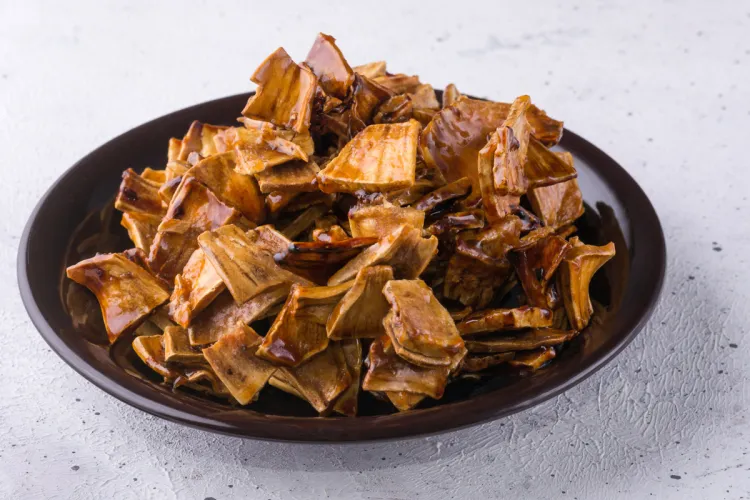 A plate with roasted breadfruit pieces mixed with sugar syrup.