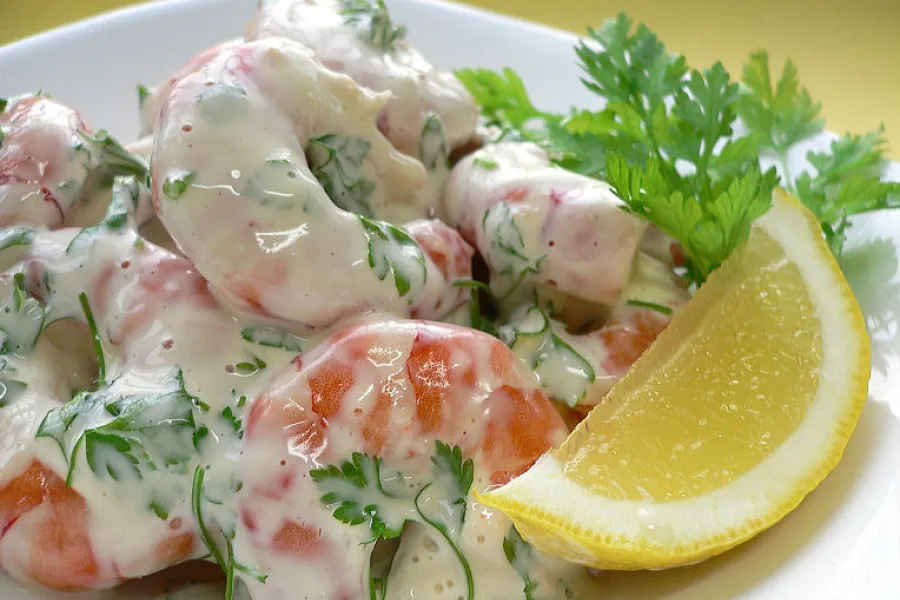 A plate of shrimp salad decorated with chervil.