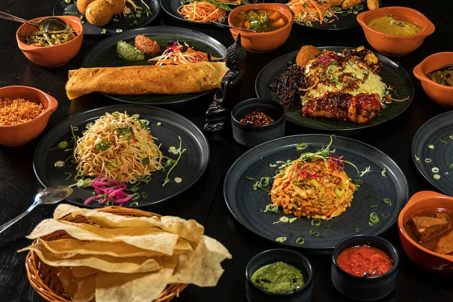 A selection of Sri Lanckan dishes on a dark wood table.