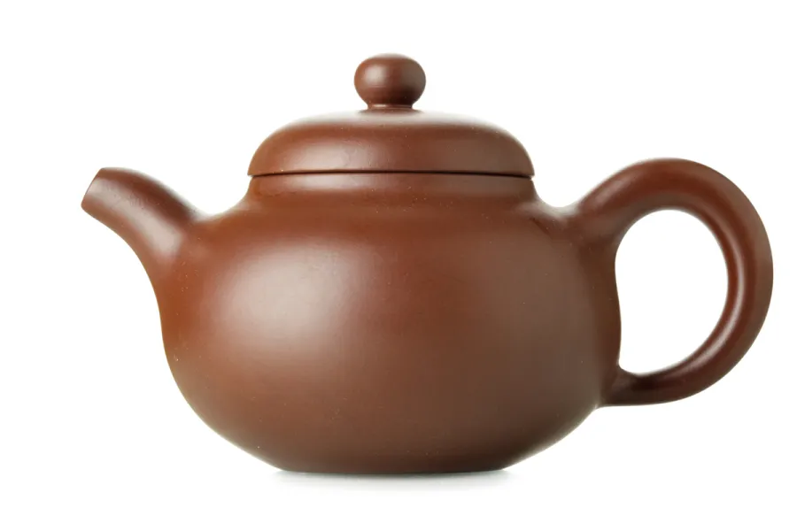 Traditional Yixing clay teapot with round body, curved spout, and lid.