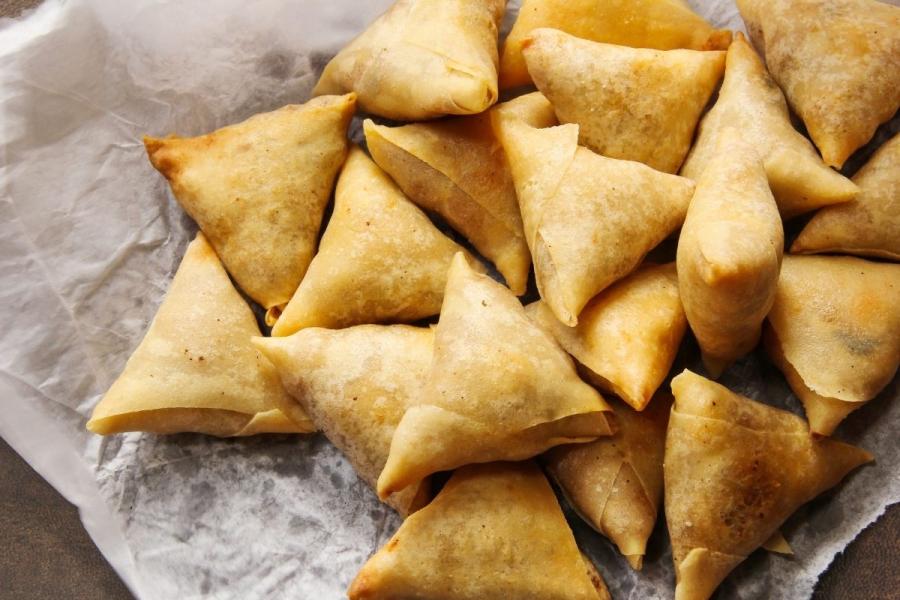 Samosas resting on kitchen paper.