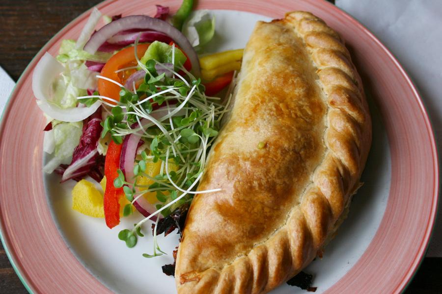 Cornish pasty and salad on a plate.